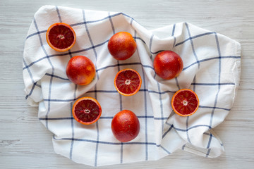 Naklejka na ściany i meble Whole and halved blood oranges on cloth, top view. Flat lay, overhead, from above.