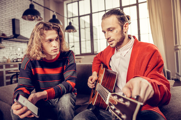 Friends using smartphone while looking for the melody to play
