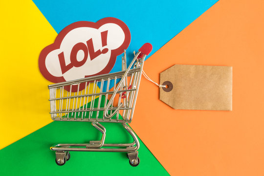 Shopping trolley toy with special offer tag and label with lol text on multicolored background minimalistic flat lay concept.