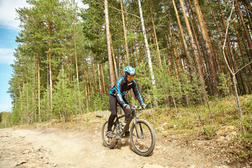 Fototapeta na wymiar cyclist riding a mountain bike along forest road