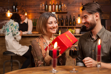 Beautiful young woman smilling after recieving a gift from her handsome boyfriend