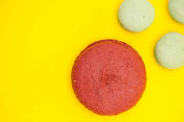 Big cherry macaroon flavour macaroon next to little green tea flavour macaroons
