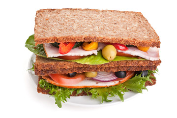 big pile of healthy whole grain bread sandwiches with  turkey, ham and vegetables