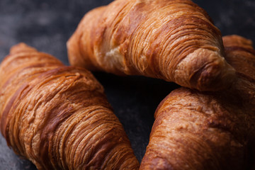 Tasty french croissants on a black wooden table