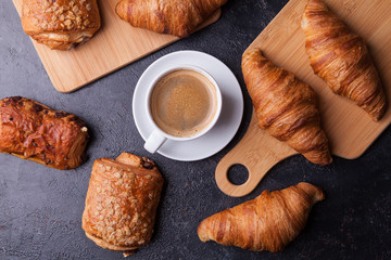 Assortment of pastries with coffee cup on wooden table background