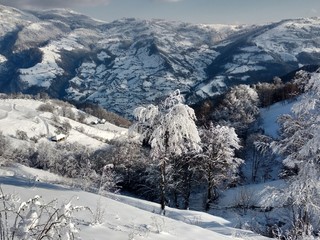 Paisaje de invierno con montañas y nieve en Rumania, pueblo de Parva, Transilvania
