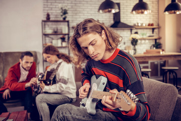 Student with bob cut feeling inspired playing the guitar