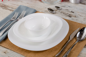 white plate table setting on wooden table.