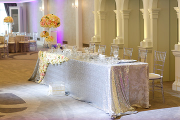 Tall white rose centerpieces at indoor wedding reception venue