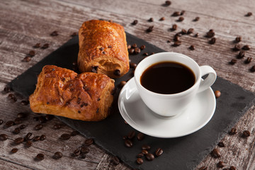 Sweet Croissants with almonds, hot coffee and spreaded coffee beans