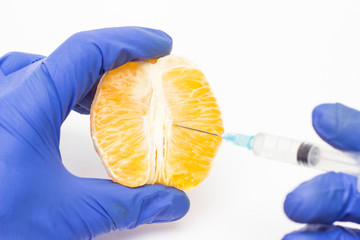 Doctor cosmetologist injects orange into the concept of the labioplasty procedure, reducing or...