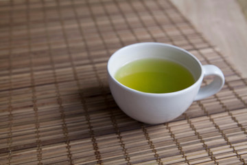 Green tea on a brown mat close-up
