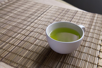Green tea on a brown mat close-up
