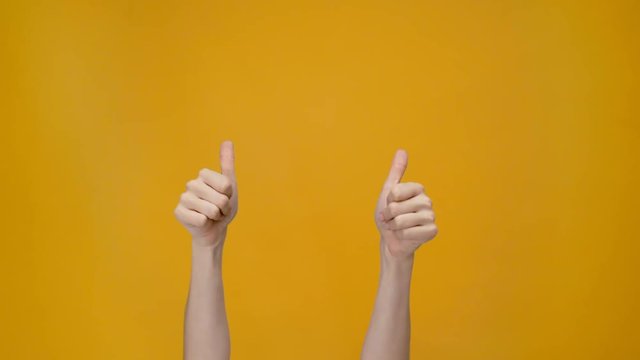 cropped view of man showing thumb up signs isolated on yellow