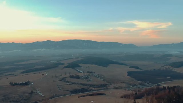 Aerial drone shot over village with beautiful view of Tlst&aacute; and Ostr&aacute; mountains in the Turiec region of Slovakia at sunset.