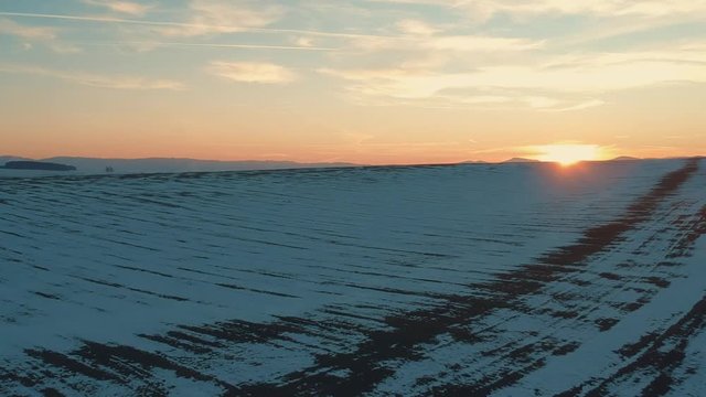 Aerial drone footage going over valley covered in snow at sunrise in the Turiec region of Slovakia