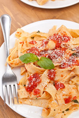 tasty pappardelle pasta with tomato marinara sauce, parmesan cheese and basil leaves