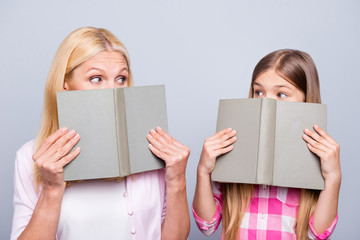 Close up photo funny funky blond hair hide cover face she her grandma little granddaughter hold read books impressions feelings wear casual pink plaid checkered shirt sweater isolated grey background