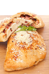 two calzone pizzas stuffed with mushrooms, ham and cheese