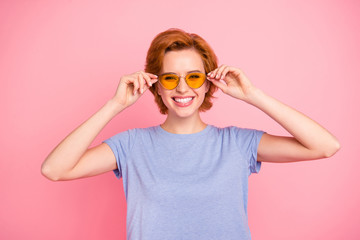 Portrait of her she nice cute charming attractive lovely cheerful cheery girl wearing casual blue t-shirt touching cool yellow glasses isolated over pink pastel background
