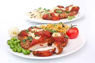 two plates of chicken parmesan on white background