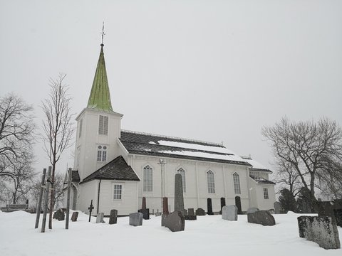 Norwegian temple surrounded by trees, around the cemetery, in winter.
