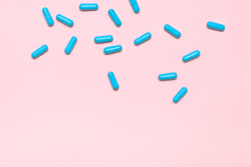 Blue pills on pink background ,top view,copy space