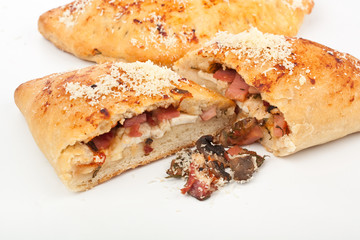 two calzone pizzas with ham, mushrooms and cheese