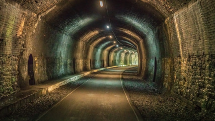 Walking through the Headstone Tunnel, near Monsal Head in the East Midlands, Derbyshire, Peak District, England, UK