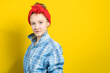 Young beautiful woman thinking looking to the side at blank copy space. Caucasian person in yellow dress and beige lipstick, redhead hair up isolated on blue studio background. Expressive face girl