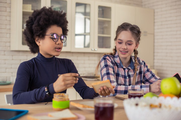Attentive international male person preparing tasty sandwich