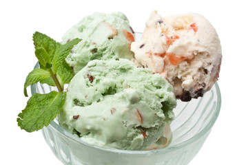 three scoops of ice cream with mint leaves in a glass