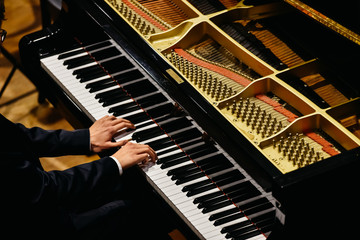 Hands of classical pianist playing his piano during a concert.