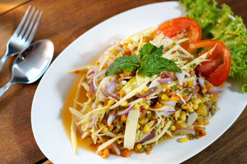 Spicy salad (Yam 3 Kai) is popular Thai food. Fish eggs, Crab eggs and horseshoe crab eggs mix with spicy sauce, chilies, mangoes and spicy herbs. Selective focus, shoot in studio, Clean food concept.