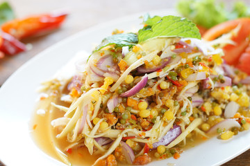 Spicy salad (Yam 3 Kai) is popular Thai food. Fish eggs, Crab eggs and horseshoe crab eggs mix with spicy sauce, chilies, mangoes and spicy herbs. Selective focus, shoot in studio, Clean food concept.