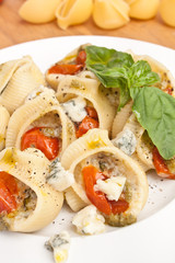 pasta shell stuffed with various cheese, pesto sauce and cherry tomatoes
