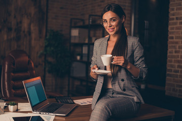 Close up photo beautiful amazing she her business lady long hair chief friendly hold hot beverage self-confident little coffee break  sit office table wear formal wear specs checkered plaid suit