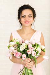 Portrait of beautiful bride with wedding bouquet of pink tulips