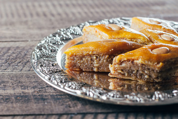 Baklava. Ramadan Dessert. Traditional Arabic dessert with nuts and honey, cup of tea on a wooden table background. Copy space