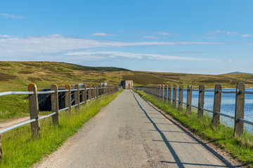 Rural road in Wales, leading over the dam at the Aled Isaf Reservoir, Conwy, Wales, UK