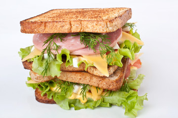 Big  healthy toasted bread, meat, lettuce and cheese sandwich on a white background