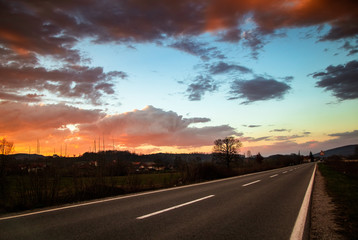 Nature landscape of sunset over the asphalt road with mountains near and beautiful sky