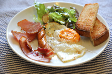 English breakfast fried egg bacon sausage bread and salad