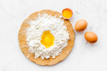 Making dough concept. Pile of flour and eggs on white background top view