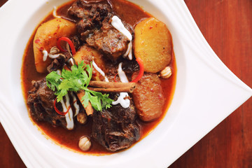 Beef massaman curry with rice and salad on wooden background , Thai food
