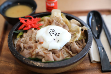Japanese food Gyudon Japanese beef on rice bowl topped with egg on wooden table