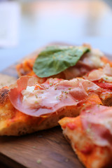 Pizza with parma ham salad rocket and parmesan on dark wooden background close up. Italian food