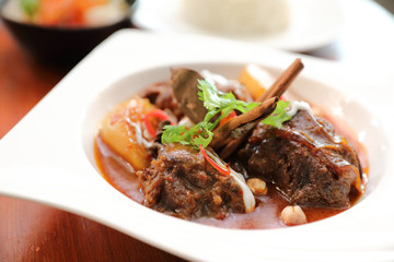 Beef massaman curry with rice and salad on wooden background , Thai food
