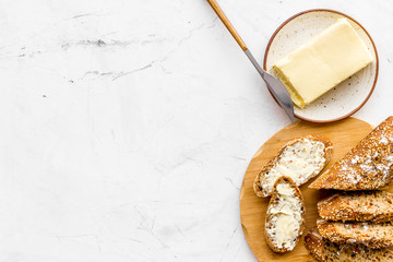 Slice of bread with butter on white background top view space for text
