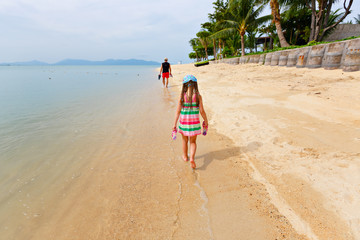 Adorable little girl walking alone white sand Caribbean beach